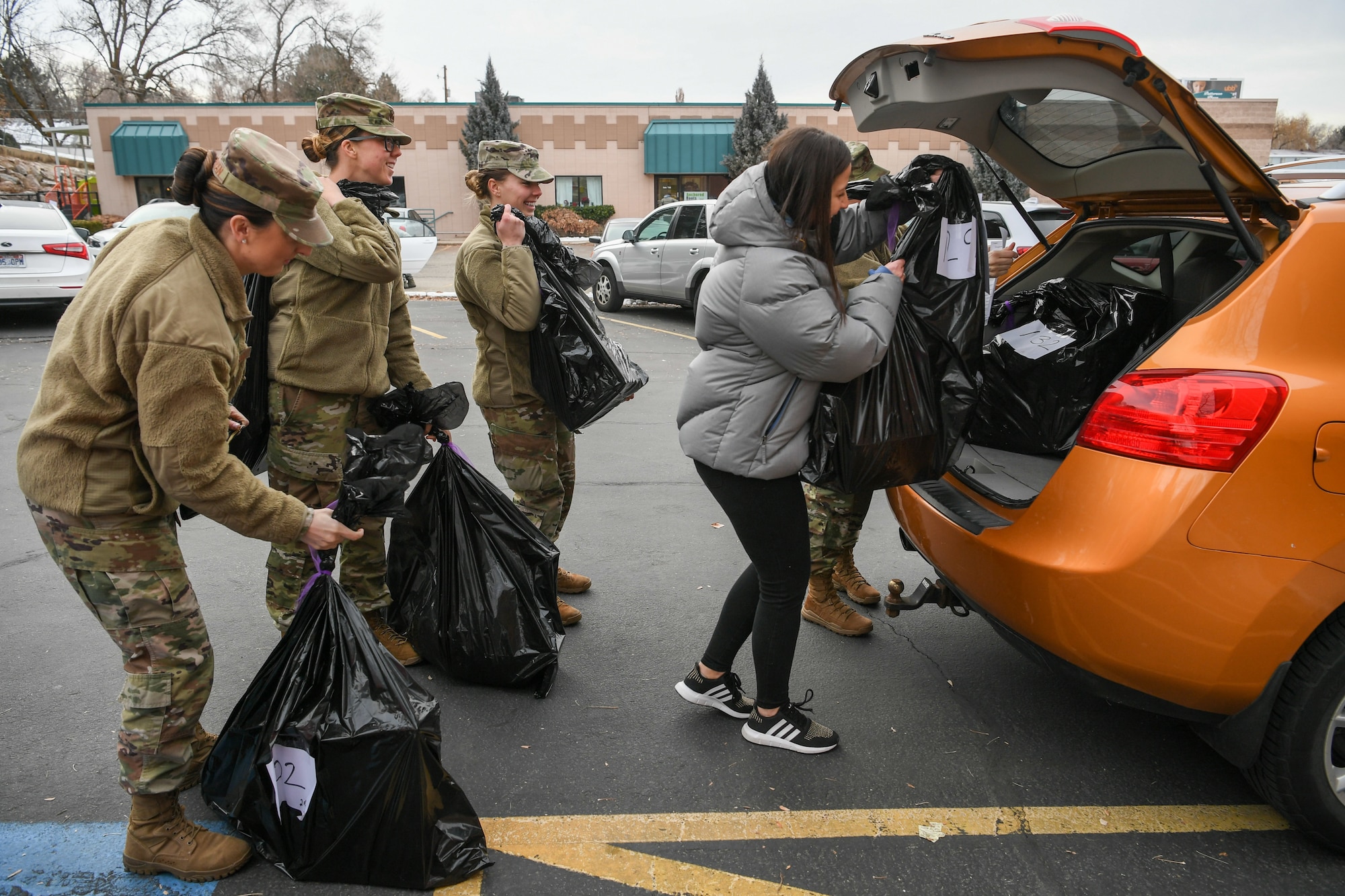 Airmen from Hill Air Force Base, Utah, load up bags of wrapped gifts at Utah Foster Care Foundation in Ogden before delivering gifts to foster children Dec. 18, 2019, as part of a volunteer effort called Santa Brigade.  Around 85 Airmen from various commands played Santa for the day delivering 537 gifts to over 140 foster care families around Northern Utah. (U.S. Air Force photo by Cynthia Griggs)