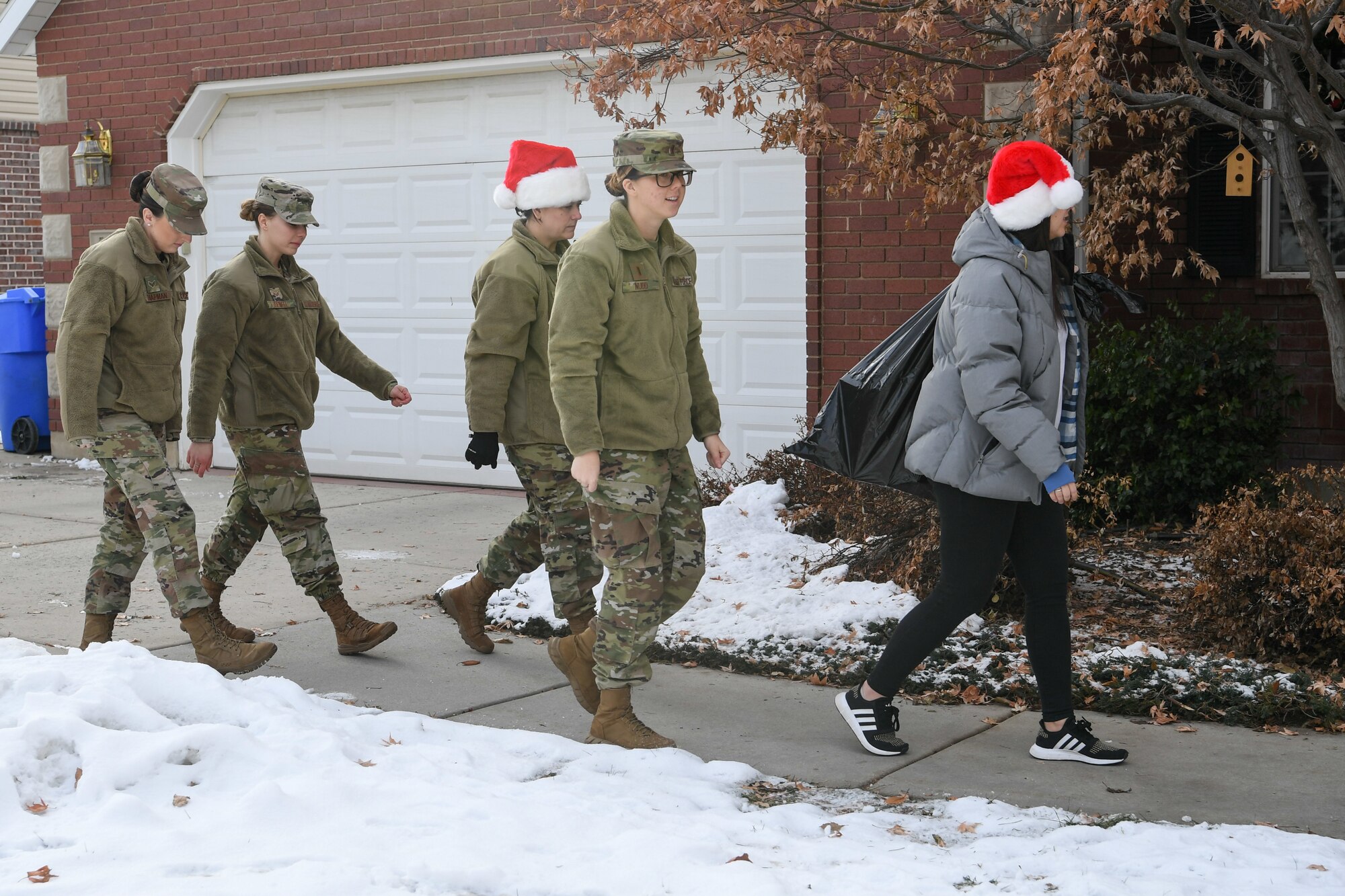 Airmen from Hill Air Force Base, Utah, deliver a bag of wrapped gifts to foster children Dec. 18, 2019, as part of a volunteer effort called Santa Brigade, a joint venture with Utah Foster Care Foundation.  Around 85 Airmen from various commands played Santa for the day delivering 537 gifts to over 140 foster care families around Northern Utah. (U.S. Air Force photo by Cynthia Griggs)
