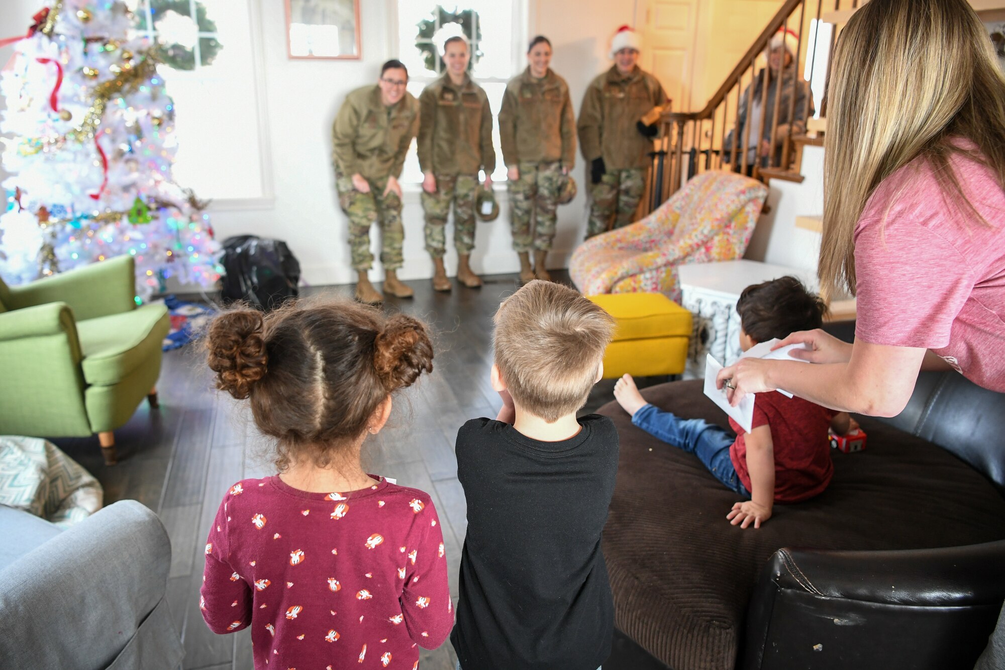 Children greet Airmen from Hill Air Force Base , Utah, as they deliver gifts Dec. 18, 2019, as part of a volunteer effort called Santa Brigade, a joint venture with Utah Foster Care Foundation.  Around 85 Airmen from various commands played Santa for the day delivering 537 gifts to over 140 foster care families around Northern Utah. (U.S. Air Force photo by Cynthia Griggs)