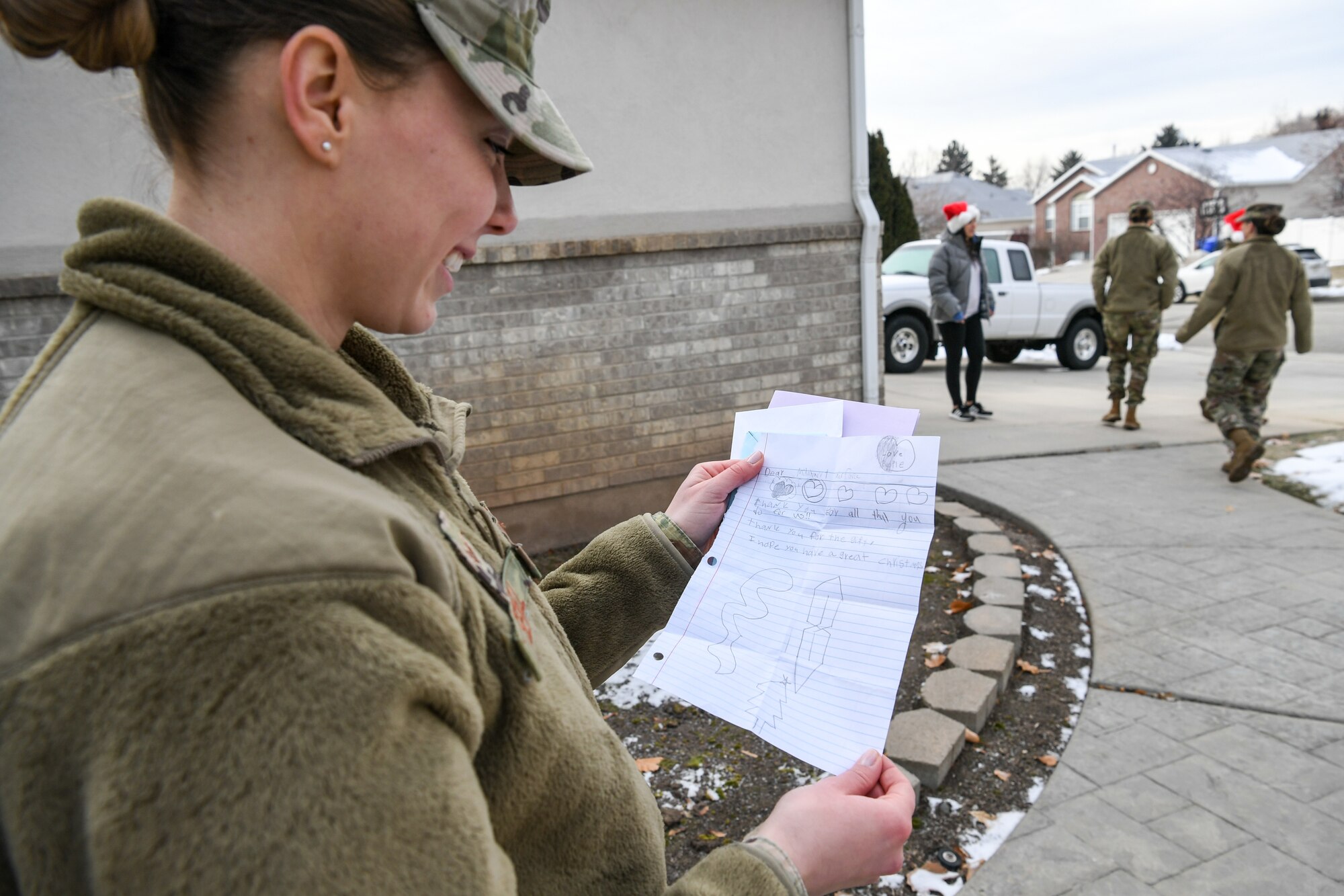 Senior Airman Hayley Sewell, 419th Medical Squadron, reads a letter from a foster child after delivering gifts Dec. 18, 2019, as part of a volunteer effort called Santa Brigade, a joint venture with Utah Foster Care Foundation and volunteers from Hill Air Force Base, Utah.  Around 85 Airmen from various commands played Santa for the day delivering 537 gifts to over 140 foster care families around Northern Utah. (U.S. Air Force photo by Cynthia Griggs)