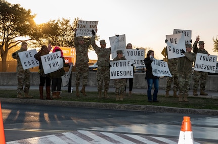 37th Training Wing military and civilian members hold positive messages of support at base gates during the morning inbound commute as part of their new initiative, “We Care,” at Joint Base San Antonio-Lackland, Texas, Dec. 18, 2019. The initiative involved 37th Training Wing military and civilian members spending the morning at various gates letting each person know that they stand together in support of those struggling with depression and thoughts of suicide by holding a positive message of support and handing out over 400 candy canes. If you are struggling with thoughts of suicide, please go directly to the Mental Health Clinic or to your closest Emergency Room. You can also reach the National Suicide Prevention Lifeline at 1-800-273-8255.