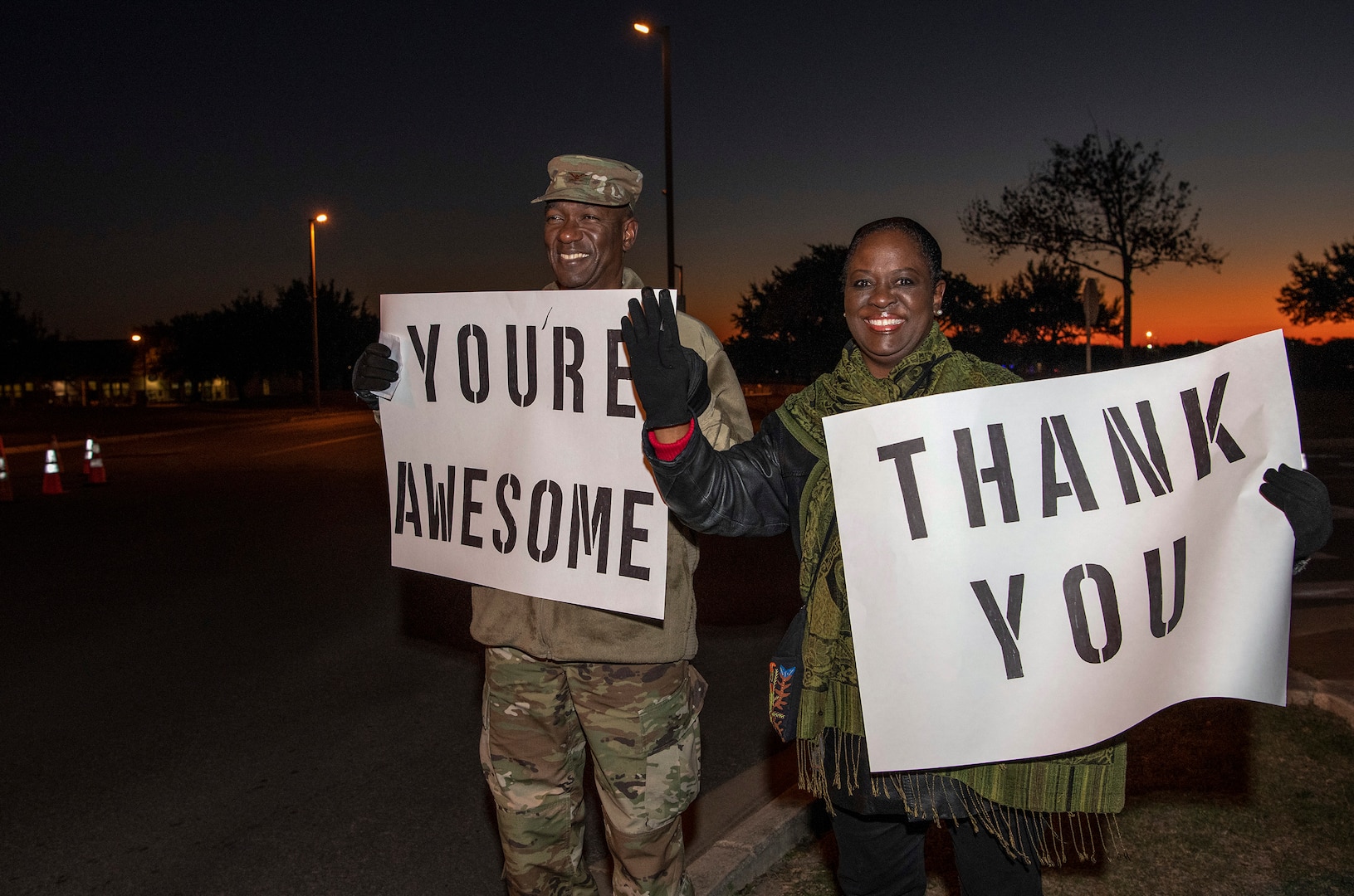 Col. Isaac Davidson, Inter-American Air Forces Academy commandant, and his wife Lydia hold positive messages of support at a base gate during the morning inbound commute as part of their new initiative, “We Care,” at Joint Base San Antonio-Lackland, Texas, Dec. 18, 2019. The initiative involved 37th Training Wing military and civilian members spending the morning at various gates letting each person know that they stand together in support of those struggling with depression and thoughts of suicide by holding a positive message of support and handing out over 400 candy canes. If you are struggling with thoughts of suicide, please go directly to the Mental Health Clinic or to your closest Emergency Room. You can also reach the National Suicide Prevention Lifeline at 1-800-273-8255.