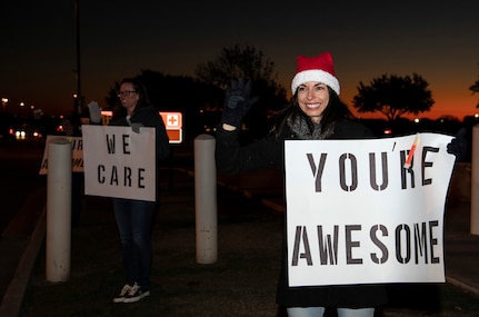 Leslie Janaros, 37th Training Wing key spouse mentor and wife of Col. Jason Janaros, 37th TRW commander, holds a positive message of support at a base gate during the morning inbound commute as part of their new initiative, “We Care,” at Joint Base San Antonio-Lackland, Texas, Dec. 18, 2019. The initiative involved 37th Training Wing military and civilian members spending the morning at various gates letting each person know that they stand together in support of those struggling with depression and thoughts of suicide by holding a positive message of support and handing out over 400 candy canes. If you are struggling with thoughts of suicide, please go directly to the Mental Health Clinic or to your closest Emergency Room. You can also reach the National Suicide Prevention Lifeline at 1-800-273-8255.