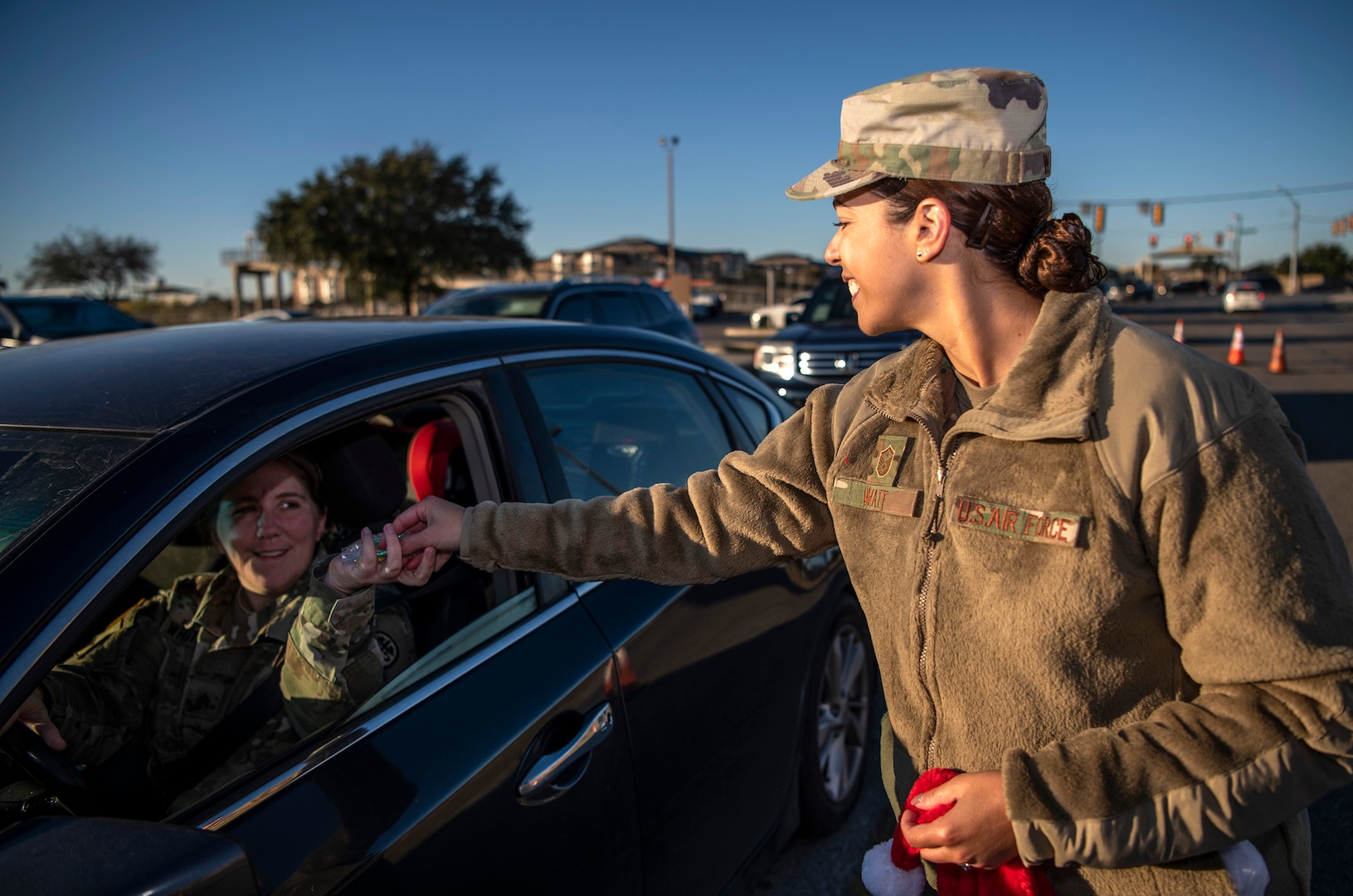 Master Sgt. Keyla Watt, Inter-American Air Forces Academy first sergeant, hands out a candy cane during the morning inbound commute in support of the 37th Training Wing new initiative, “We Care,” at Joint Base San Antonio-Lackland, Texas, Dec. 18, 2019. The initiative involved 37th Training Wing military and civilian members spending the morning at various gates letting each person know that they stand together in support of those struggling with depression and thoughts of suicide by holding a positive message of support and handing out over 400 candy canes. If you are struggling with thoughts of suicide, please go directly to the Mental Health Clinic or to your closest Emergency Room. You can also reach the National Suicide Prevention Lifeline at 1-800-273-8255.