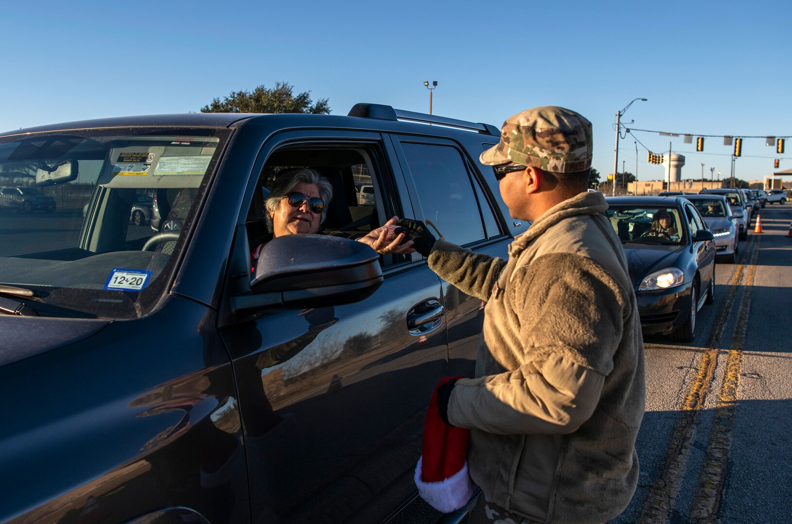Staff Sgt. Henin Rios Arauz, Inter-American Air Forces Academy, hands out a candy cane during the morning inbound commute in support of the 37th Training Wing new initiative, “We Care,” at Joint Base San Antonio-Lackland, Texas, Dec. 18, 2019. The initiative involved 37th Training Wing military and civilian members spending the morning at various gates letting each person know that they stand together in support of those struggling with depression and thoughts of suicide by holding a positive message of support and handing out over 400 candy canes. If you are struggling with thoughts of suicide, please go directly to the Mental Health Clinic or to your closest Emergency Room. You can also reach the National Suicide Prevention Lifeline at 1-800-273-8255.