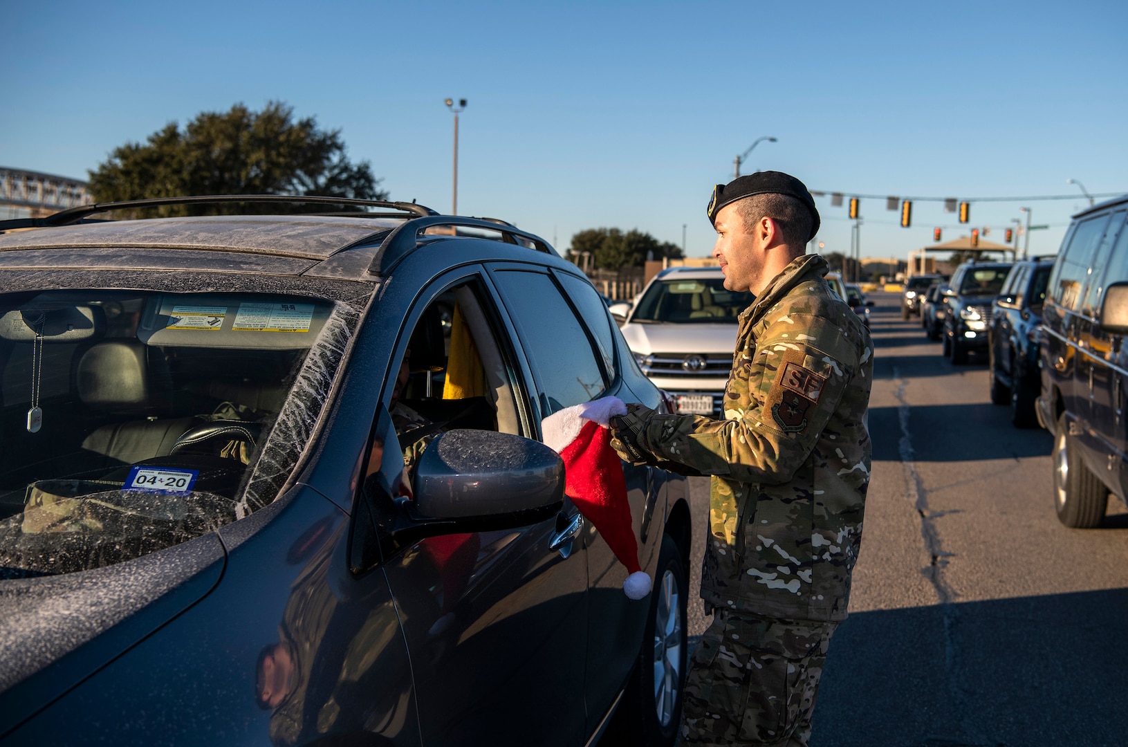 Capt. Jason Mag, 837th Training Squadron, hands out a candy cane during the morning inbound commute in support of the 37th Training Wing new initiative, “We Care,” at Joint Base San Antonio-Lackland, Texas, Dec. 18, 2019. The initiative involved 37th Training Wing military and civilian members spending the morning at various gates letting each person know that they stand together in support of those struggling with depression and thoughts of suicide by holding a positive message of support and handing out over 400 candy canes. If you are struggling with thoughts of suicide, please go directly to the Mental Health Clinic or to your closest Emergency Room. You can also reach the National Suicide Prevention Lifeline at 1-800-273-8255.