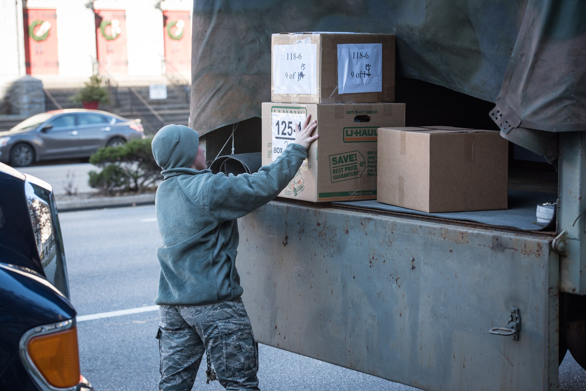 U.S. Air Force Airman 1st Class Emily Harsomchuck, a command post emergency actions controller with the 193rd Special Operations Wing, Pennsylvania Air National Guard, loads boxes of donated-gifts onto a light medium tactical vehicle, during the 30th Annual Holiday Wish Program