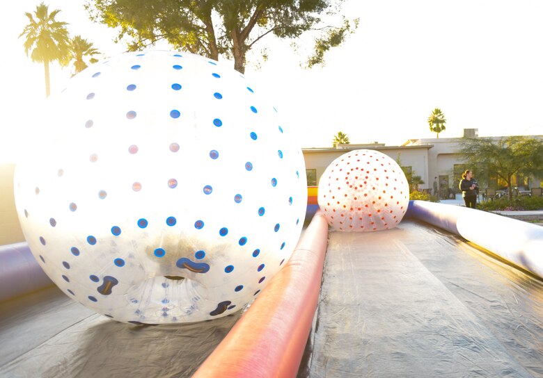 A photo of children playing in human hamster balls.