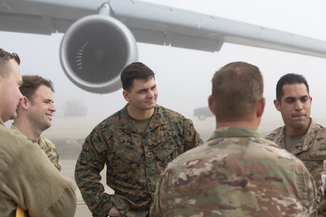 .S. Marines and airmen discuss embarkation of Marine Corps equipment into a C-5 Galaxy aircraft at March Air Force Base, Calif. Dec. 5, 2019.