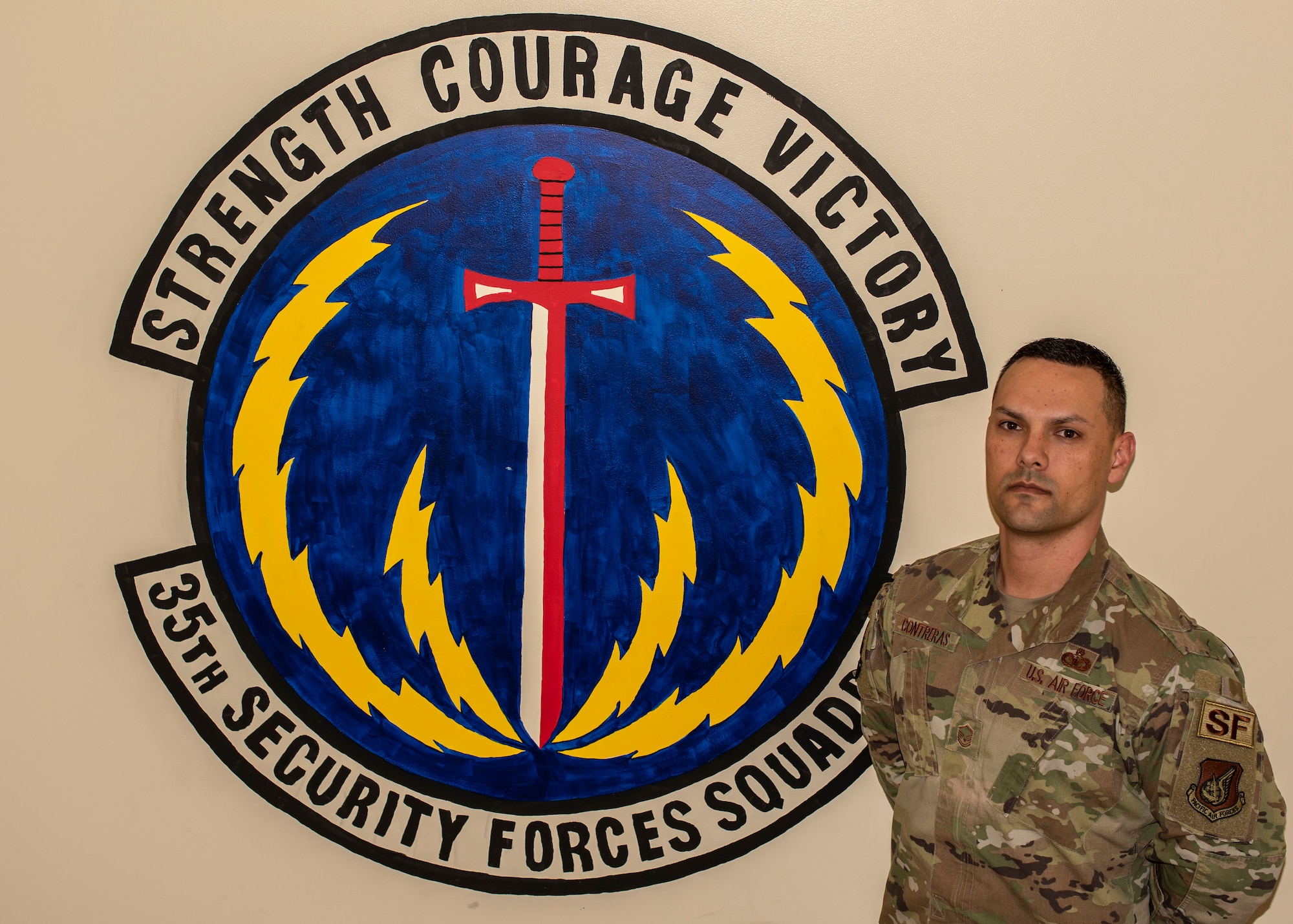 Master Sgt. Andrew Contreras, a 35th Security Forces Squadron chief of standardization and evaluations, pauses for a photo in front of the squadron’s insignia at Misawa Air Base, Japan, Dec. 17, 2019. Contreras won the Col. Billy Jack Carter Award by stepping into a detachment superintendent position while deployed in South Korea, working with individuals from different jobs and Pacific Air Force bases. The award honors a security forces member for a specific act, contribution or event. (U.S. Air Force photo by Airman 1st Class China M. Shock)