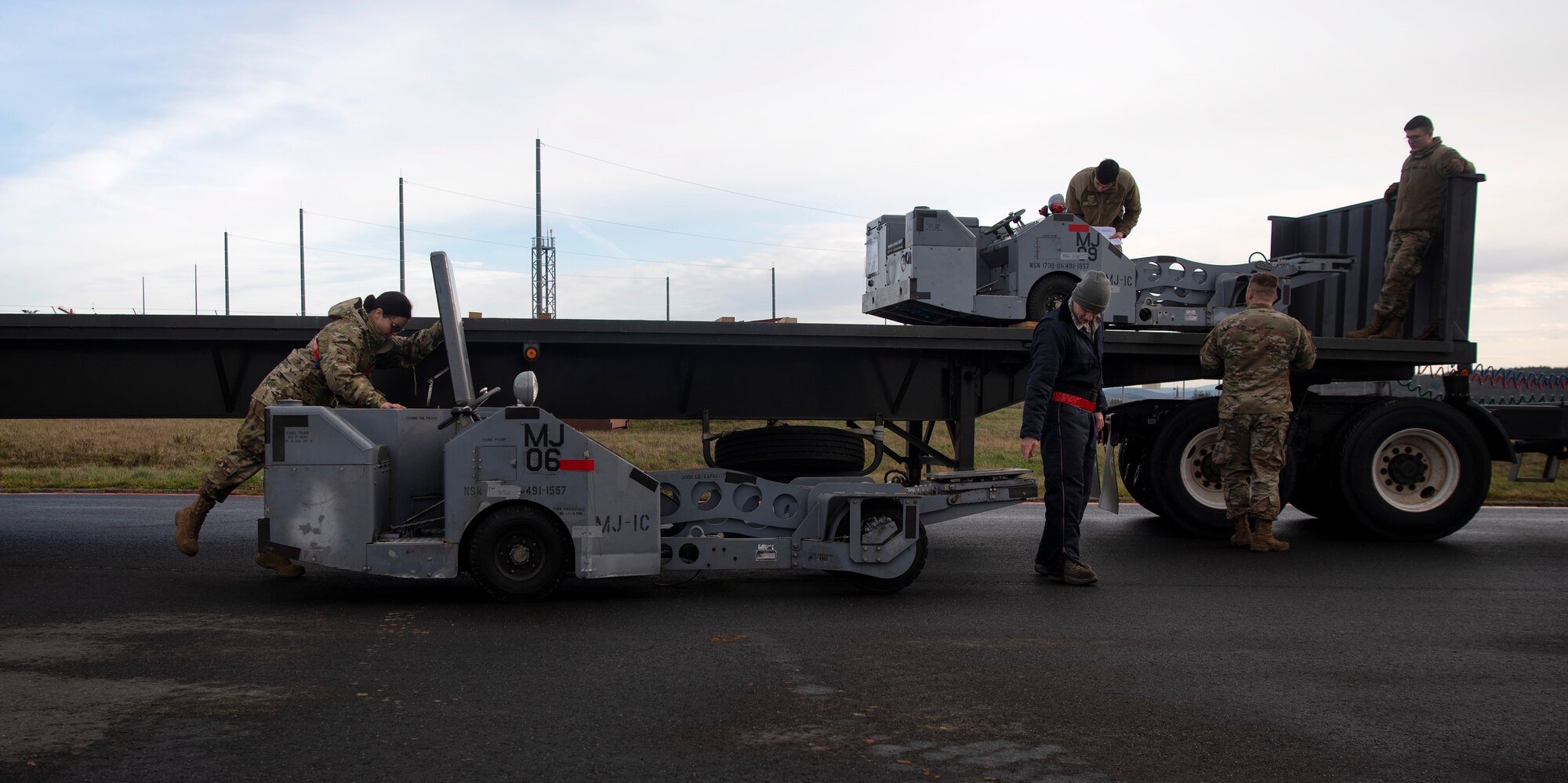 U.S. Air Force Airmen from the 52nd Fighter Wing unload jammers on the flightline at Spangdahlem Air Base, Germany, Dec. 17, 2019. A small team of Airman conducted an Agile Combat Employment exercise to ensure readiness for any potential short-notice threat. Jammers are used to load munitions onto aircraft. (U.S. Air Force photo by Airman 1st Class Valerie Seelye)