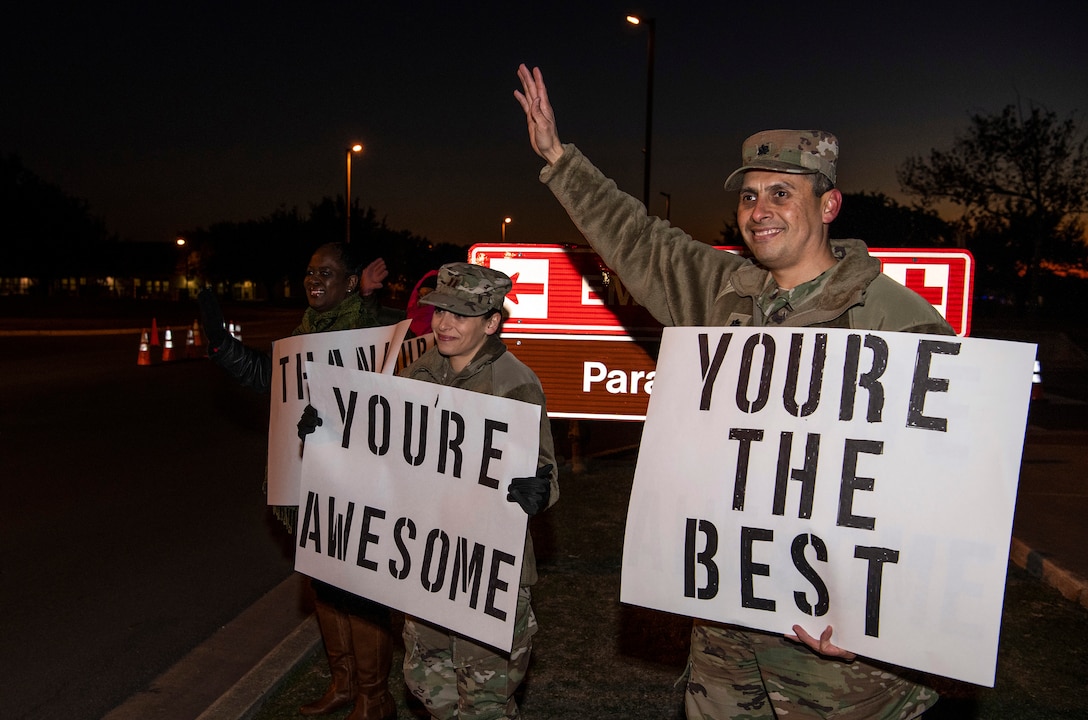 From right, Lt. Col. Raymundo Vann, 323rd Training Squadron commander, Capt. Jessica Stanley, 737th Training Group and Lydia Davidson, wife of Col. Isaac Davidson, Inter-American Air Forces Academy commandant, hold positive messages of support at a base gate during the morning inbound commute as part of their new initiative, “We Care,” at Joint Base San Antonio-Lackland, Texas, Dec. 18, 2019. The initiative involved 37th Training Wing military and civilian members spending the morning at various gates letting each person know that they stand together in support of those struggling with depression and thoughts of suicide by holding a positive message of support and handing out over 400 candy canes. If you are struggling with thoughts of suicide, please go directly to the Mental Health Clinic or to your closest Emergency Room. You can also reach the National Suicide Prevention Lifeline at 1-800-273-8255.