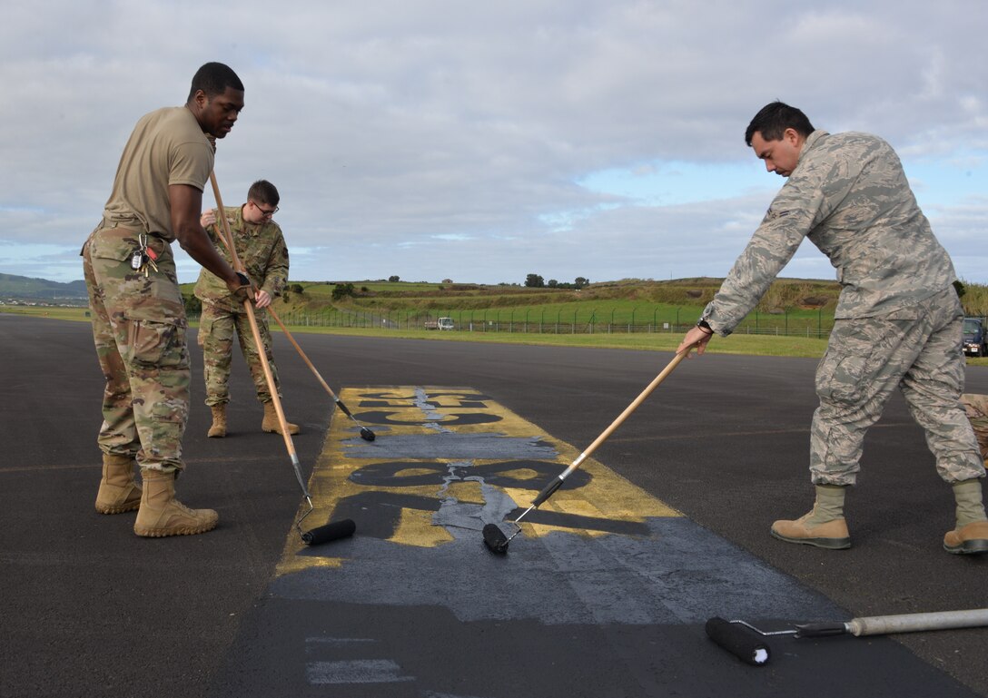 U.S. Air Force Airmen from the 786th Civil Engineer Squadron paint over runway markings at Lajes Field, Portugal, Dec 12, 2019. The changes get the landing zone one step closer to being certified and operational. (U.S. Air Force photo by Ricky Baptista)