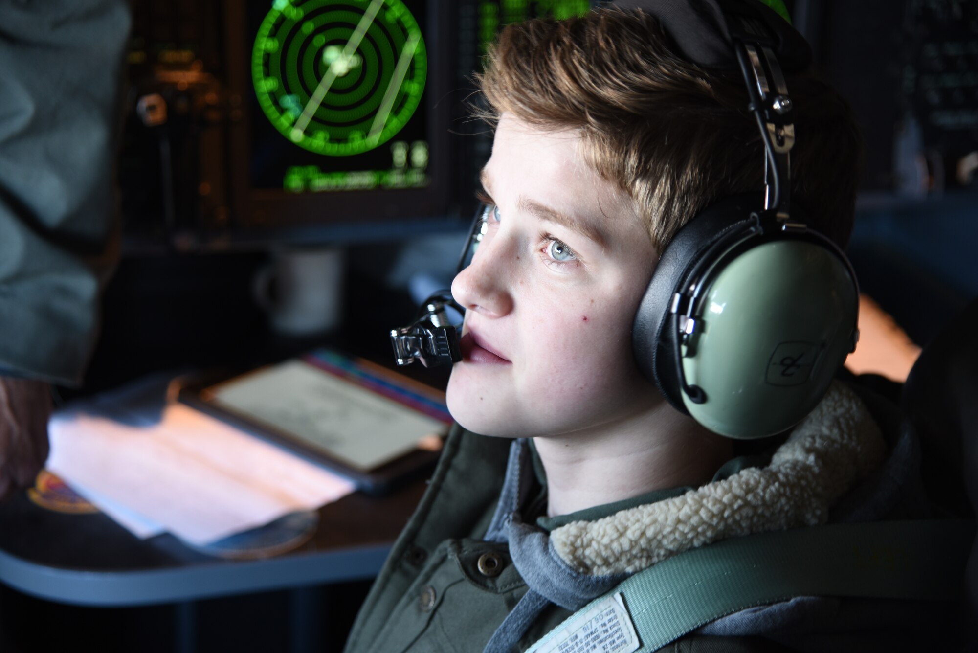 Honorary 2nd Lt. Charles “Payton” Burge listens over his headset to Lt. Col. Sean Cross, 53rd Weather Reconnaissance Squadron deputy director of operations, during the Pilot for a Day program Dec. 19, at Keesler Air Force Base, Miss. The 403rd Wing collaborated with Make A Wish Mississippi who selects the children who will participate in the program. (U.S. Air Force photo by Tech. Sgt. Christopher Carranza)