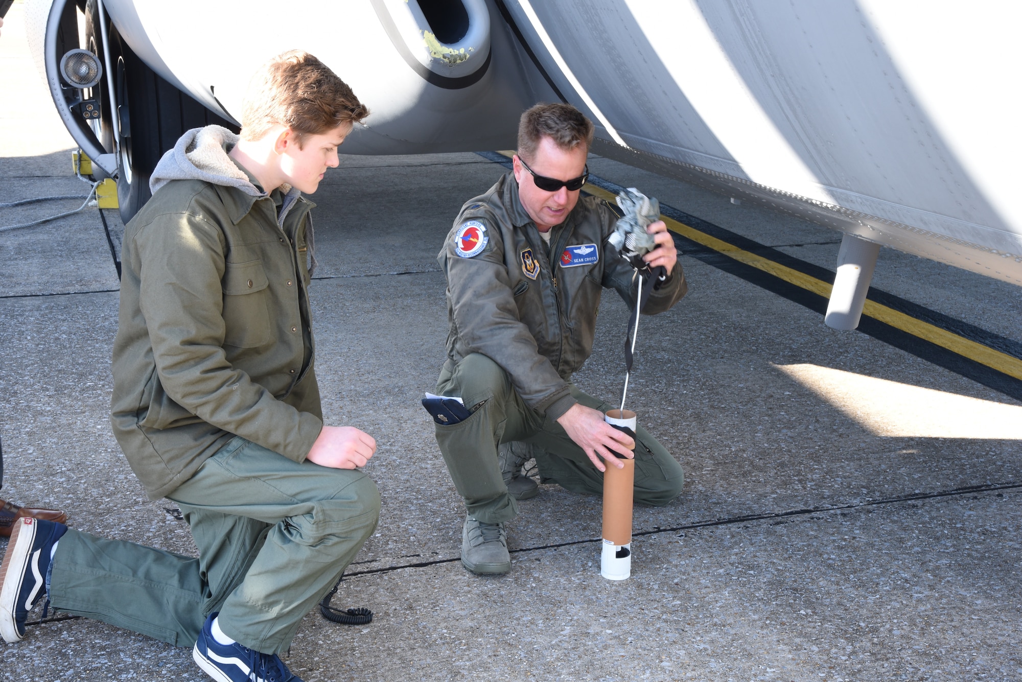 Lt. Col. Sean Cross, 53rd Weather Reconnaissance Squadron deputy director of operations, demonstrates how a dropsonde works to honorary 2nd Lt. Charles “Payton” Burge, during the Pilot for a Day program Dec. 19, at Keesler Air Force Base, Miss. The 403rd Wing collaborated with Make A Wish Mississippi who selects the children who will participate in the Program. (U.S. Air Force photo by Lt. Col. Marnee A.C. Losurdo)