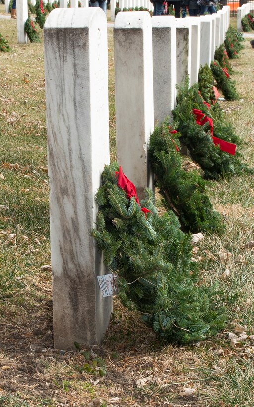 A wreath leans on a headstone at Offutt Air Force Base, Neb., Dec. 14, 2019. Wreaths were placed on each headstone and eight ceremonial wreaths honored the four armed services, the Coast Guard, the Merchant Marines, POW/MIA, and the 22 veterans and active duty service members who take their lives each day.