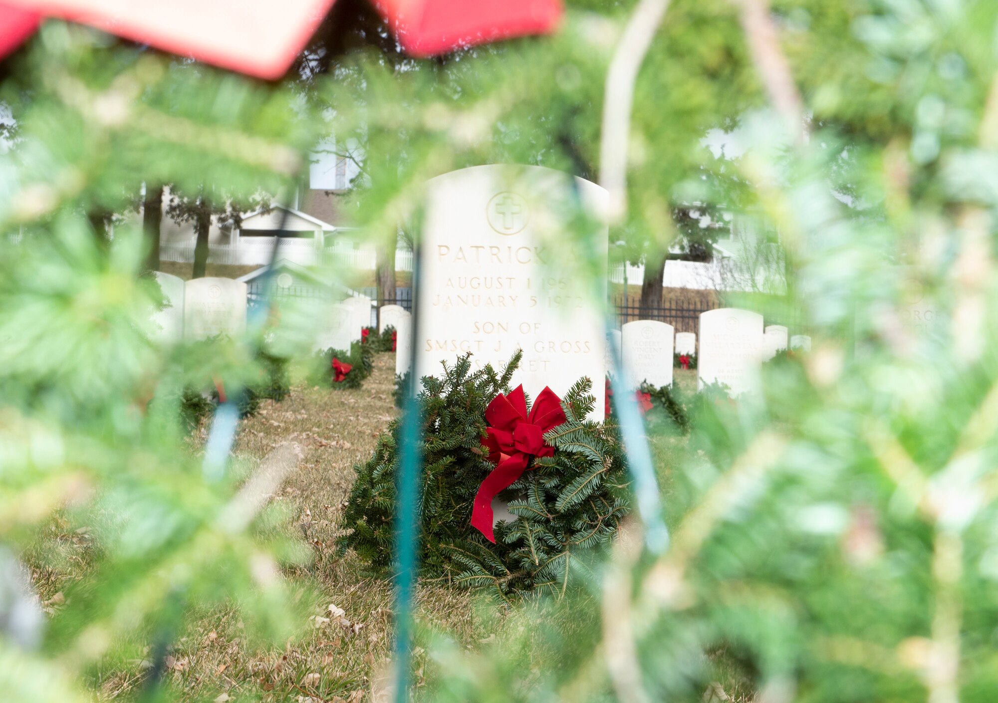A wreath leans on a headstone at Offutt Air Force Base, Neb., Dec. 14, 2019. Wreaths were placed on each headstone and eight ceremonial wreaths honored the four armed services, the Coast Guard, the Merchant Marines, POW/MIA, and the 22 veterans and active duty service members who take their lives each day.