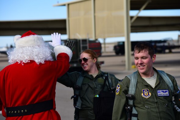 Pilots, returning from a flight, greet Santa Claus on the flightline at Laughlin Air Force Base, Texas, Dec. 17, 2019. As part of an ongoing cooperation between Laughlin and the North Pole, Col. Lee Gentile, 47th Flying Training Wing commander, met with Santa to enhance the base’s Specialized Undergraduate Pilot Training program by providing student pilots an opportunity of a lifetime—delivering presents all across the United States. (U.S. Air Force photo by Senior Airman Anne McCready)