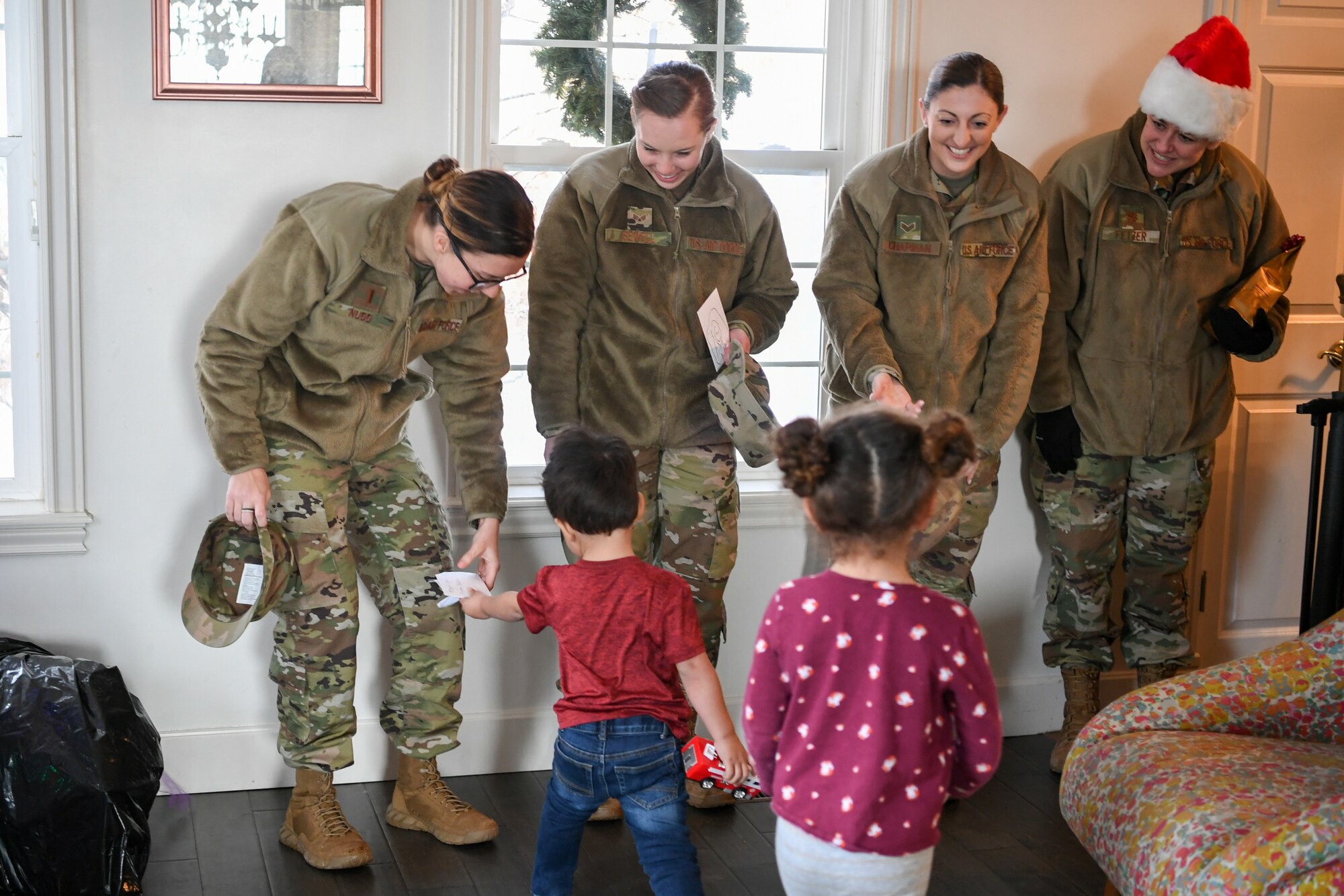 (Left to right) 2nd Lt. Kassidi Nudd, Senior Airmen Hayley Sewell, Senior Airman Brianne Chapman, and Maj. Christy Fetzer, 419th Fighter Wing, receive cards from foster children after delivering gifts Dec. 18, 2019, as part of a volunteer effort called Santa Brigade, a joint venture with Utah Foster Care Foundation and volunteers from Hill Air Force Base, Utah.  Around 85 Airmen from various commands played Santa for the day delivering 537 gifts to over 140 foster care families around Northern Utah. (U.S. Air Force photo by Cynthia Griggs)