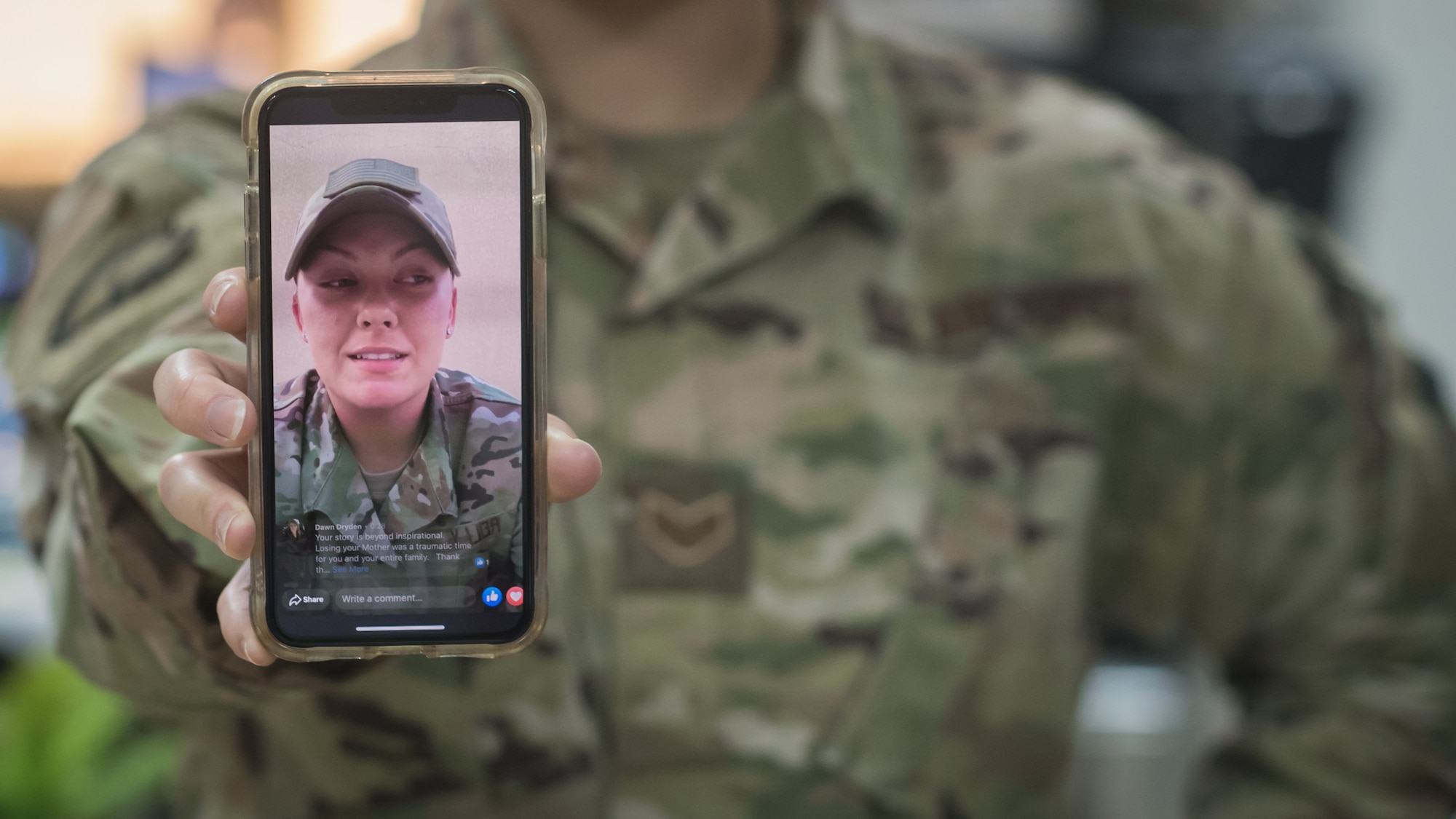 U.S. Air Force Staff Sgt. Alyssa Reilly, assigned to the 386th Expeditionary Security Forces Squadron, holds her phone as her video plays. Her video soon went viral after it was posted, eventually being shared by a Facebook group with more than 320,000 followers. (U.S. Air Force photo by Tech. Sgt. Daniel Martinez)