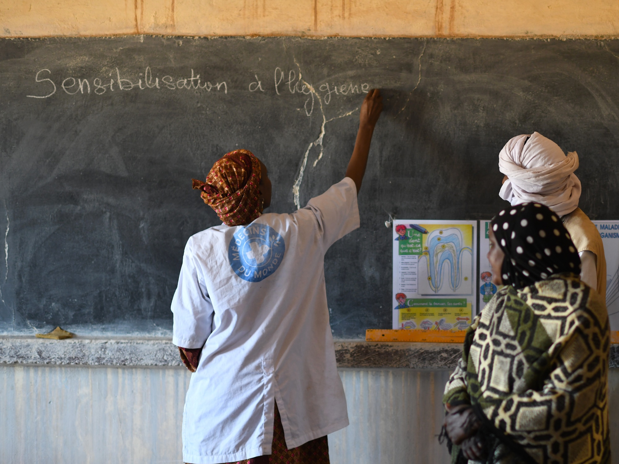 Dr. Mahaman Aicha, an Agadez city dentist, teaches a dental hygiene course to local school children in the village of Tsakatalam, Niger, Dec. 14, 2019. The U.S. Army 443rd Civil Affairs Battalion Civil Affairs Team 219 deployed to Nigerien Air Base 201 partnered with the dentist to teach the Tsakatalam Primary School students for the first time how to properly brush and floss their teeth and the importance of good oral health. (U.S. Air Force photo by Staff Sgt. Alex Fox Echols III)