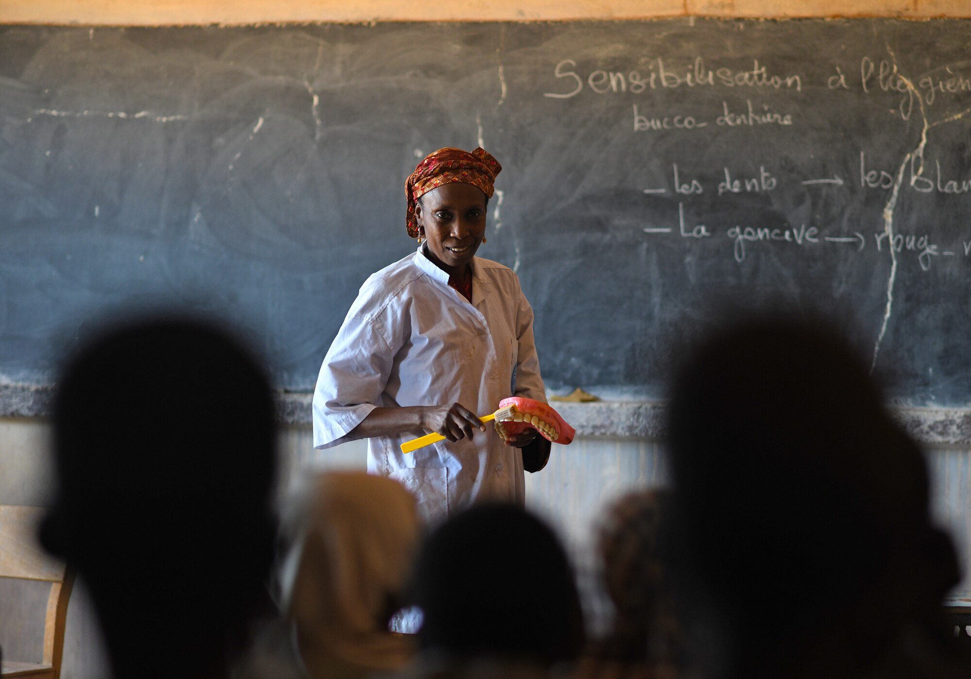 Dr. Mahaman Aicha, an Agadez city dentist, teaches a dental hygiene course to local school children in the village of Tsakatalam, Niger, Dec. 14, 2019. The U.S. Army 443rd Civil Affairs Battalion Civil Affairs Team 219 deployed to Nigerien Air Base 201 partnered with the dentist to teach the Tsakatalam Primary School students for the first time how to properly brush and floss their teeth and the importance of good oral health. (U.S. Air Force photo by Staff Sgt. Alex Fox Echols III)