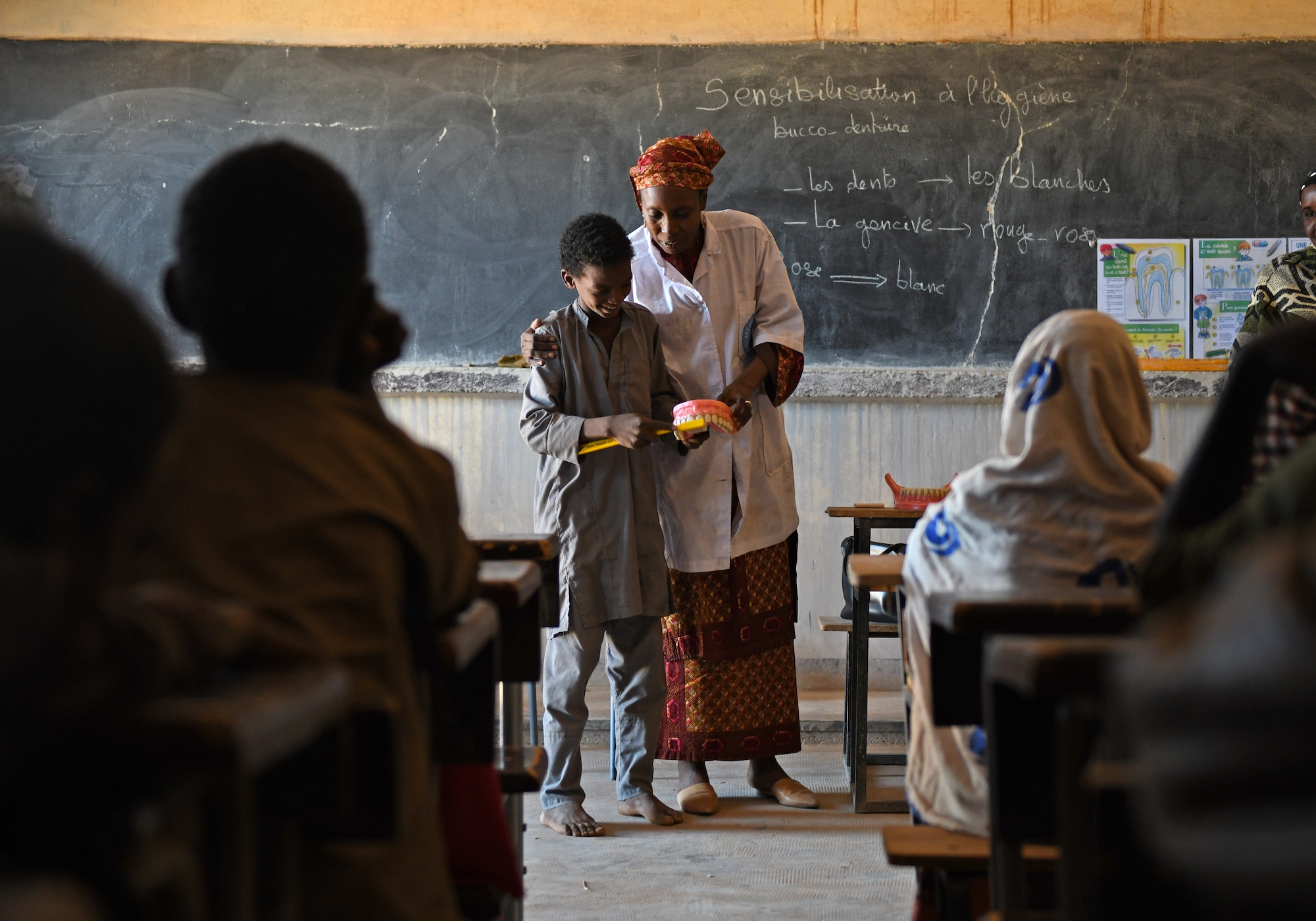 Dr. Mahaman Aicha, an Agadez city dentist, teaches a dental hygiene course to local school children in the village of Tsakatalam, Niger, Dec. 14, 2019. The U.S. Army 443rd Civil Affairs Battalion Civil Affairs Team 219 deployed to Nigerien Air Base 201 partnered with the dentist to teach the Tsakatalam Primary School students for the first time how to properly brush and floss their teeth and the importance of good oral health. (U.S. Air Force photo by Staff Sgt. Alex Fox Echols III)