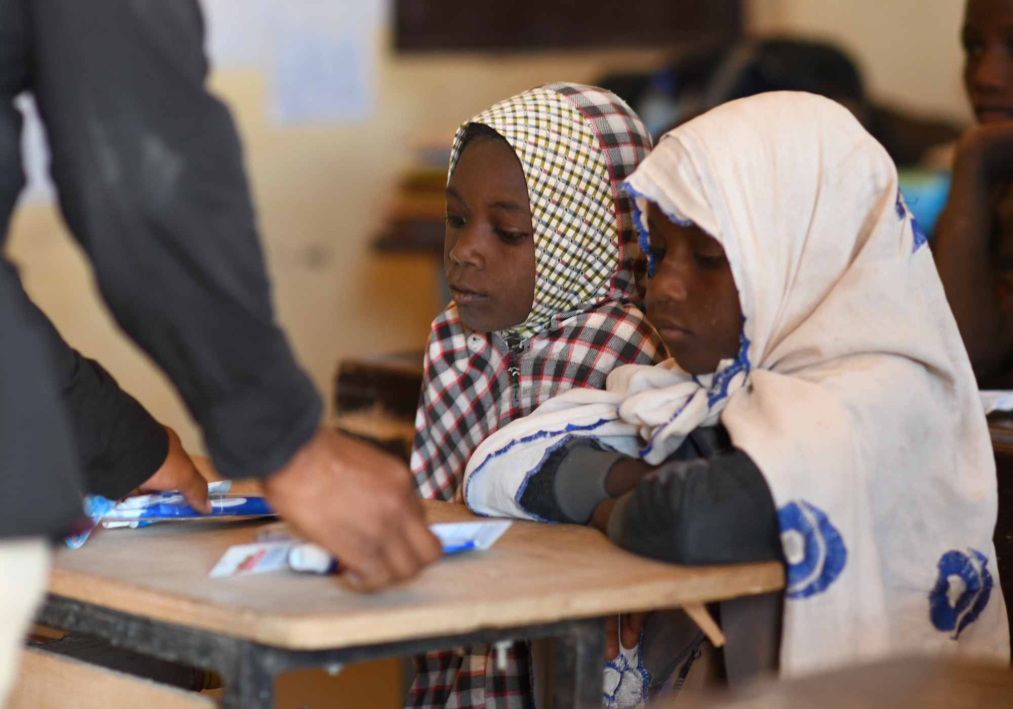 A U.S. Airmen deployed to the 724th Expeditionary Air Base Squadron distributes dental supplies to local school children during a dental hygiene course in the village of Tsakatalam, Niger, Dec. 14, 2019. The U.S. Army 443rd Civil Affairs Battalion Civil Affairs Team 219 deployed to Nigerien Air Base 201 partnered with local Agadez city dentist, Dr. Mahaman Aicha, to teach the Tsakatalam Primary School students for the first time how to properly brush and floss their teeth and the importance of good oral health. (U.S. Air Force photo by Staff Sgt. Alex Fox Echols III)