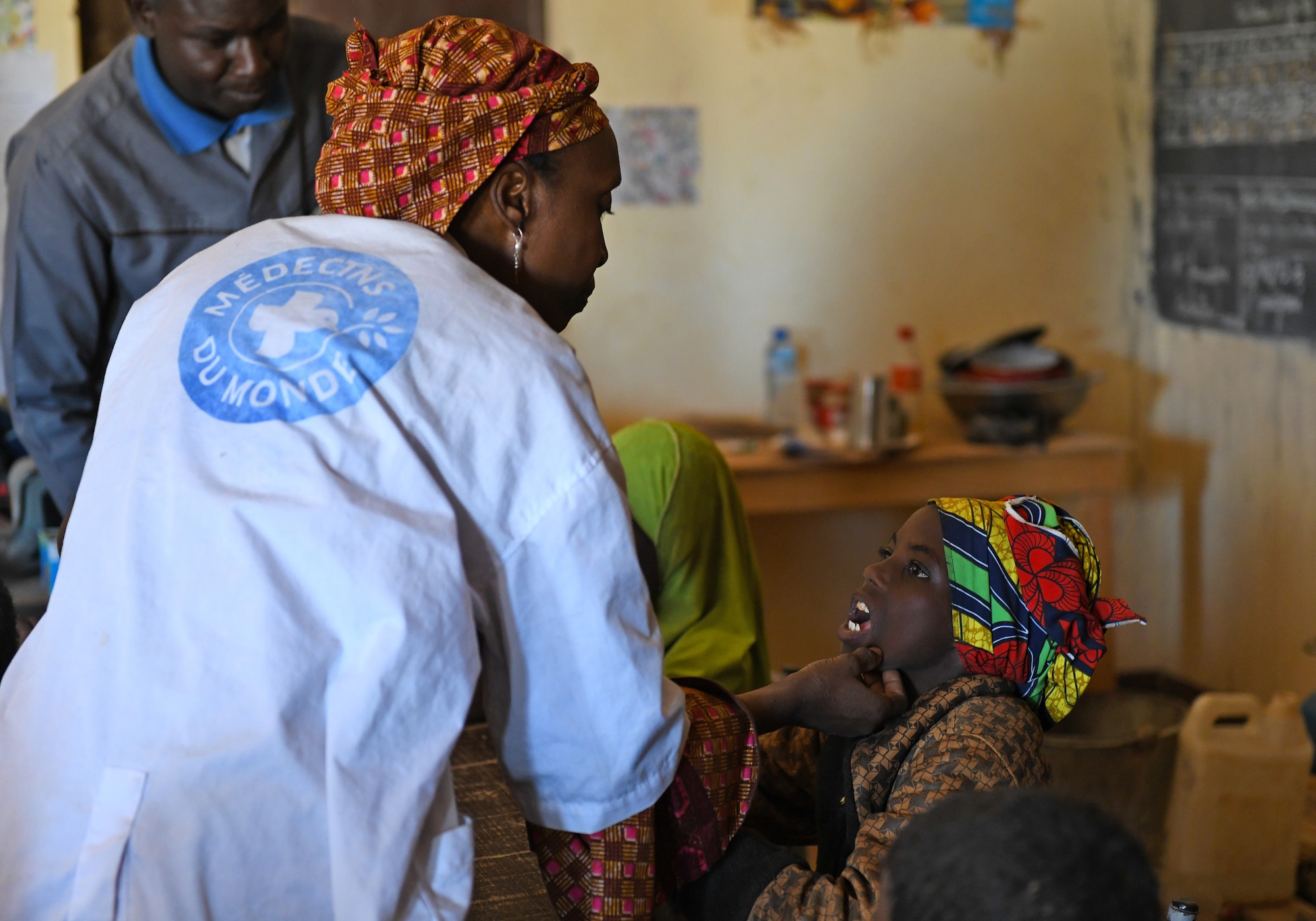 Dr. Mahaman Aicha, an Agadez city dentist, inspects the teeth of a local student in the village of Tsakatalam, Niger, Dec. 14, 2019. The U.S. Army 443rd Civil Affairs Battalion Civil Affairs Team 219 deployed to Nigerien Air Base 201 partnered with the dentist to teach the Tsakatalam Primary School students for the first time how to properly brush and floss their teeth and the importance of good oral health. (U.S. Air Force photo by Staff Sgt. Alex Fox Echols III)