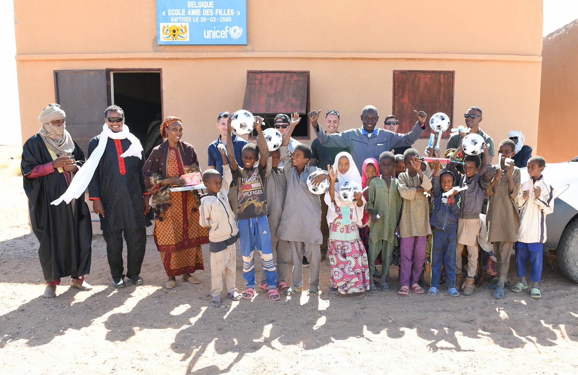 U.S. Airmen and Soldiers along with local dignitaries, students and healthcare providers take a group photo in commemoration of the first ever dental hygiene course in the village of Tsakatalam, Niger, Dec. 14, 2019. The U.S. Army 443rd Civil Affairs Battalion Civil Affairs Team 219 deployed to Nigerien Air Base 201 partnered with local Agadez city dentist, Dr. Mahaman Aicha, to teach the Tsakatalam Primary School students for the first time how to properly brush and floss their teeth and the importance of good oral health. (U.S. Air Force photo by Staff Sgt. Alex Fox Echols III)