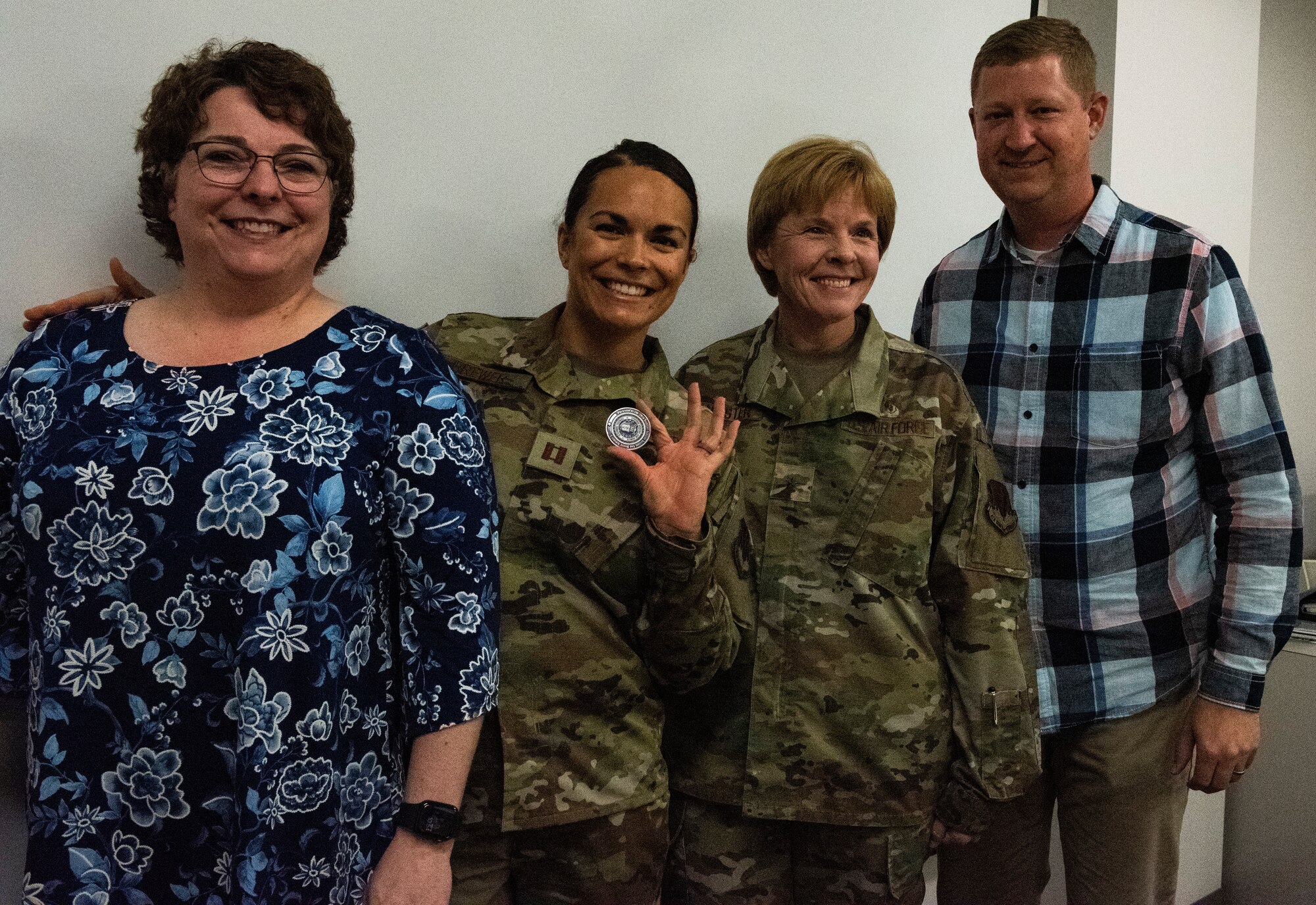 U.S. Air Force Capt. Alissa Brewer, 325th Operational Medical Readiness Squadron dentist, center, poses for a photo with her mother, left, her husband, right, and U.S. Air Force Brig. Gen. Sharon Bannister, Air combat Command Surgeon General, at Tyndall Air Force Base, Florida, Dec. 20, 2019. Brewer holds a coin presented to her by the general for her hard work and dedication to unit success. (U.S. Air Force photo by Staff Sgt. Magen M. Reeves)