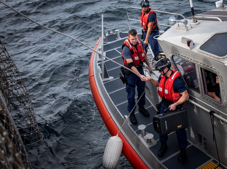 Coast Guardsmen secure communications equipment to a line to bring it aboard USS Thomas Hudner (DDG 116) in the Gulf of Mexico Dec. 16, 2019. The Navy used that equipment during the first demonstration of the Advanced Battle Management System, operators across the Air Force, Army, Navy and industry tested multiple real-time data sharing tools and technology in a homeland defense-based scenario enacted by U.S. Northern Command and enabled by Air Force senior leaders at Eglin Air Force Base, Fla., Dec. 16-18. (U.S. Air Force photo by 2nd Lt. Karissa Rodriguez)