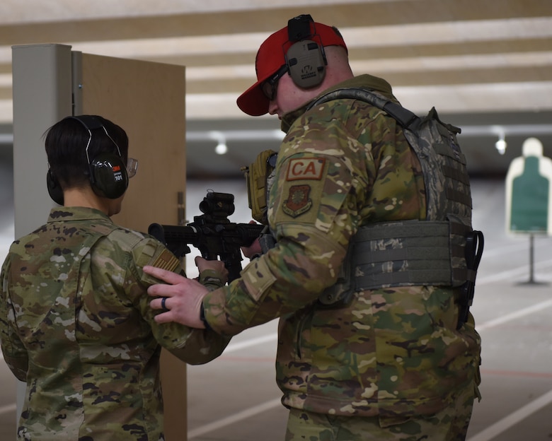 Staff Sgt. Britton Smith, 460th Security Forces Squadron combat arms instructor, teaches Chief Master Sgt. Jeannie Sousa, 460th Medical Group superintendent, how to properly hold a weapon at the 460th Security Forces Combat Arms Training and Maintenance facility at Buckley Air Force Base, Colo., Dec. 19, 2019.
