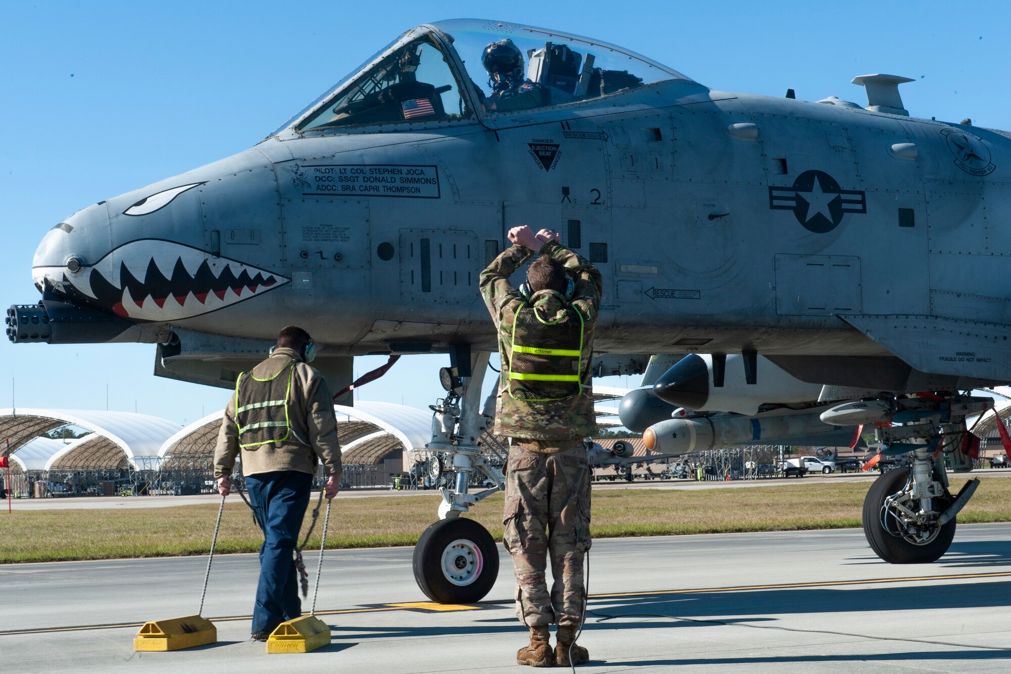 Photo of two Airmen and an A-10C Thunderbolt II