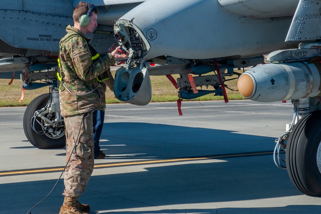Photo of an Airmen inspecting a gas cap
