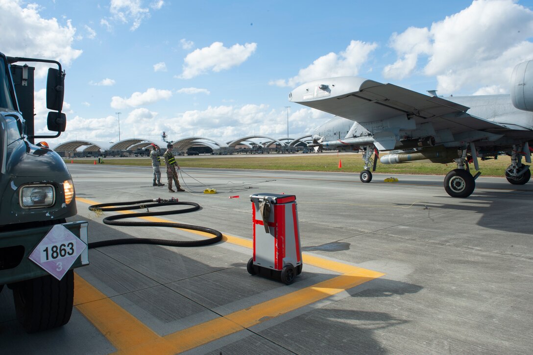 Photo of two Airmen and an A-10C Thunderbolt II
