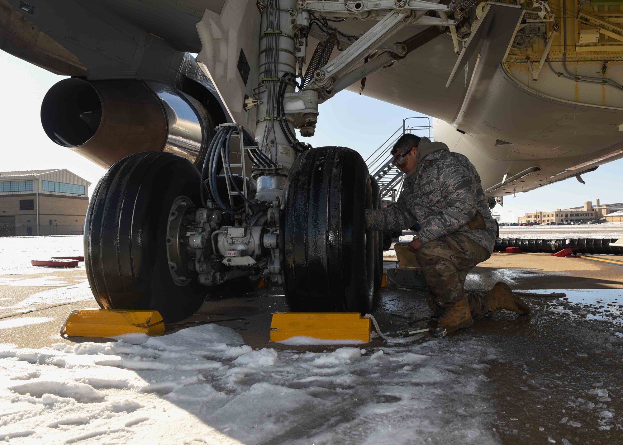Airman 1st Class Emanuel Perez, 22nd Aircraft Maintenance Squadron crew chief, checks the tire pressure on a KC-135 Stratotanker during a pre-flight inspection Dec. 17, 2019, at McConnell Air Force Base, Kan. Despite freezing conditions pre-flight inspections must happen every 72 hours and include an interior and exterior check of the aircraft for any abnormalities. (U.S. Air Force photo by Airman 1st Class Alexi Bosarge)