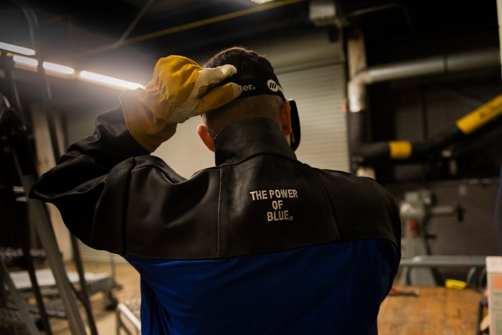 A photo of an Airman putting on a protective mask