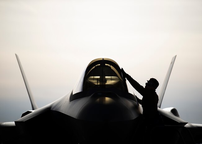 An Airman cleans the canopy of an F-35A Lighting II fighter jet.