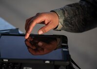 An Airmen touches a tablet.