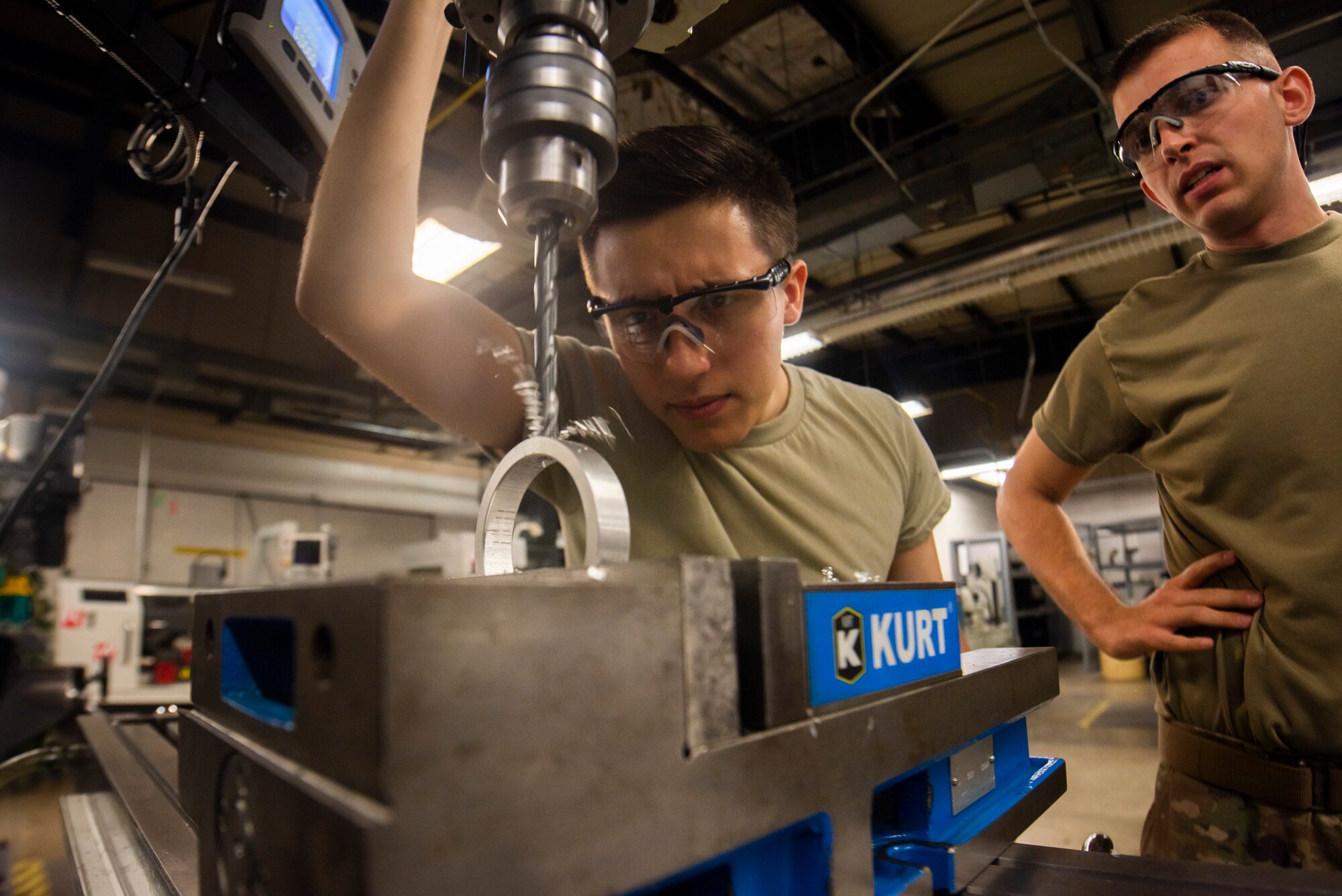 A photo of Airmen drilling into a bushing