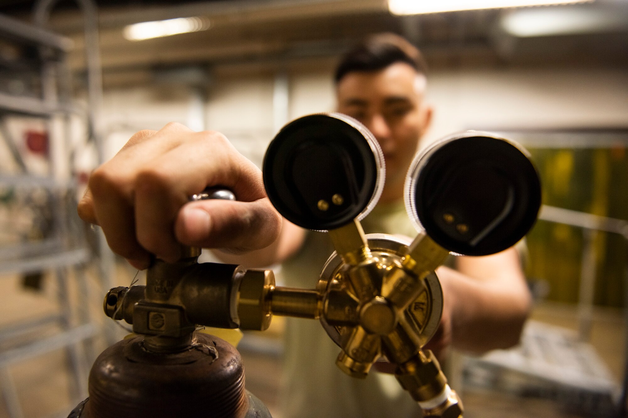 A photo of an Airman turning a knob on a gas welder.