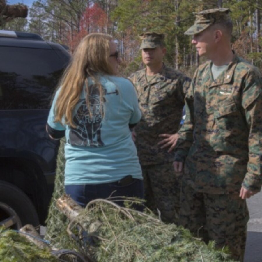 U.S. Marine Corps Col. Mikel Huber, commanding officer of Marine Corps Air Station (MCAS) Cherry, and U.S. Marine Corps Sgt. Maj. James Robertson, sergeant major of MCAS Cherry Point, speak with Jen Merlo, the Single Marine Program (SMP) coordinator during the 14th annual Trees for Troops event at MCAS Cherry Point, North Carolina, Dec. 6, 2019. Volunteers with the SMP helped distribute more than 400 free trees to service members and their families as a symbol of brotherhood and appreciation for the community during the holiday season. (U.S. Marine Corps photo by Cpl. Alexandra Amor Santos Arambulo)