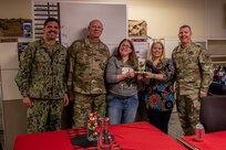 Joint Task Force Civil Support (JTF-CS) Commanding General U.S. Maj. Gen. William “Bill” Hall (far right) and Deputy Director of Intel and the command’s 1st Sgt., U.S. Navy Senior Chief Intelligence Specialist Damon Cable (far left) present members of the command’s operations directorate this year’s holiday door decoration contest award. Members shown are U.S. Army Col. Christopher Caldwell (second from left), director of operations, U.S. Navy Operations Specialist Second Class Brittany Proctor (second from right) and U.S. Navy Operations Specialist Second Class Carrie Kramer (middle). Proctor and Kramer decorated the directorate’s door this year. (Official DoD photo by Mass Communication Specialist 3rd Class Michael Redd/RELEASED)