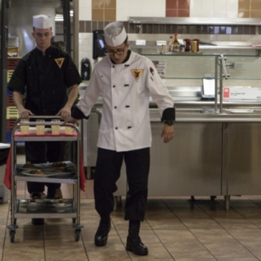 U.S. Marine Corps Lance Cpl. Edwin Aristizabal, a food service specialist assigned to Headquarters and Headquarters Squadron, Marine Corps Air Station (MCAS) Cherry Point, North Carolina, brings out his meal before a panel of judges at a Chef of the Quarter event at MCAS Cherry Point, North Carolina, Dec. 13, 2019. Each contestant presented a meal to a panel of four judges and were scored based on a variety of things including presentation and taste. (U.S. Marine Corps photo by Lance Cpl. Jacob Bertram)