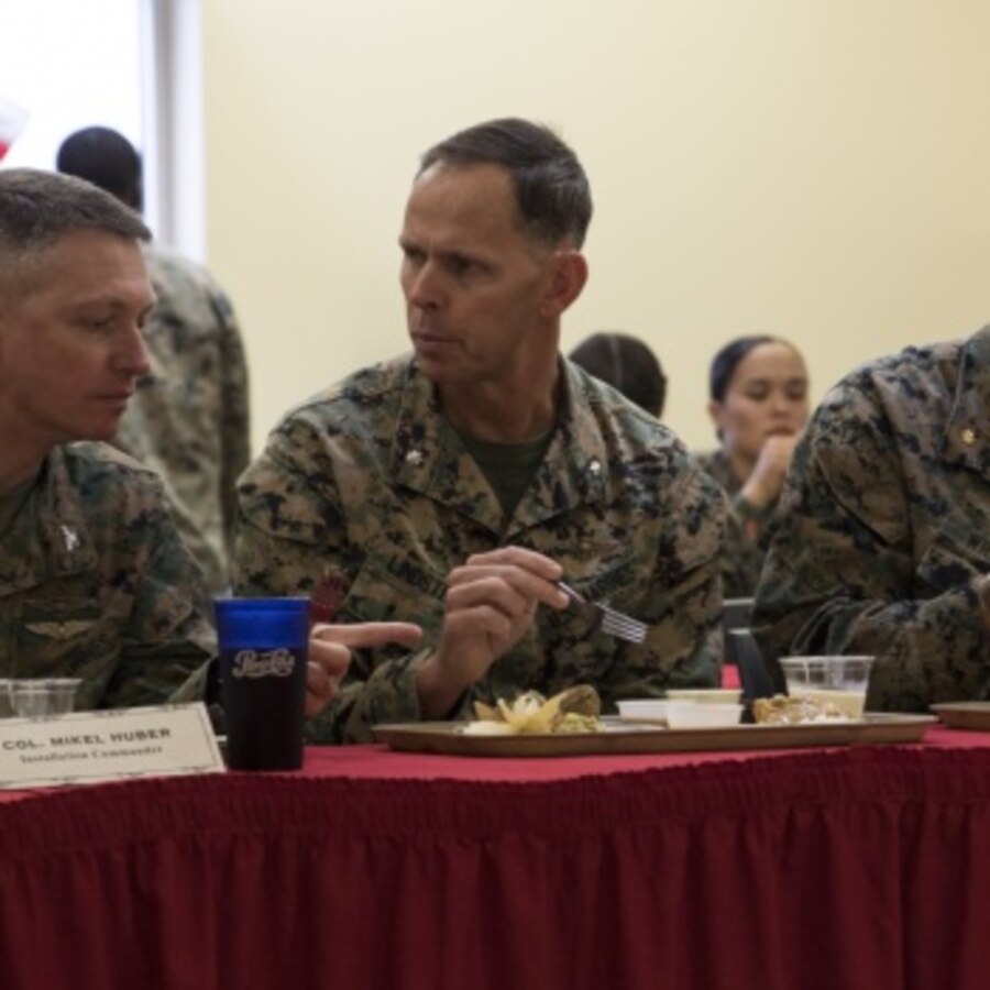 U.S. Marine Corps Col. Mikel Huber, commanding officer of Marine Corps Air Station (MCAS) Cherry Point, left, Lt. Col. Patrick Lindstrom, executive officer of MCAS Cherry Point, center, and Maj. Charles Wheeler III, logistics director of MCAS Cherry Point, eat together at a Chef of the Quarter event at MCAS Cherry Point, North Carolina, Dec. 13, 2019. This event gives food service specialists the chance to expand their culinary expertise and battle it out with their colleagues. (U.S. Marine Corps photo by Lance Cpl. Jacob Bertram)