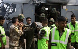 U.S. Air Force Lt. Col. Nelson Pacheco and Lt. Col. (Dr.) William Chu, Pacific Air Forces International Health Specialists, off-load a patient from Mi-17 during a medical subject matter expert exchange at Kakinada Beach, India, Nov. 20, 2019. The SMEE focused on lessons learned and table top exercises on performing humanitarian disaster and relief operations in a post-disaster environment, where roads, air and seaports are no longer accessible due to a natural disaster. (Courtesy photo)