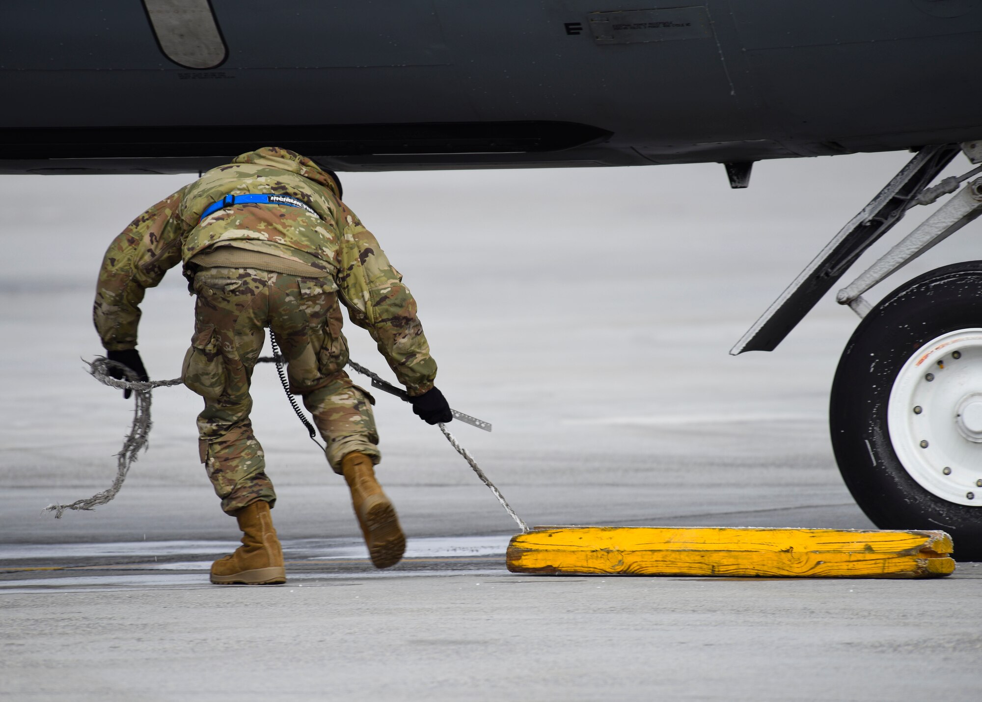 U.S. Air Force Senior Airman Zachery Murray, 92nd Aircraft Maintenance Squadron crew chief, removes a chalk from behind the landing gear of a KC-135 Stratotanker during Exercise Titan Fury at Fairchild Air Force Base, Washington, Dec. 9, 2019.