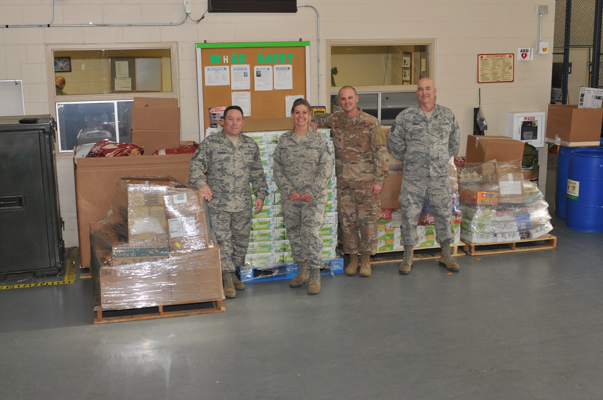 Four members of the 185th stand next to over 6,400 pound of food loaded onto pallets.