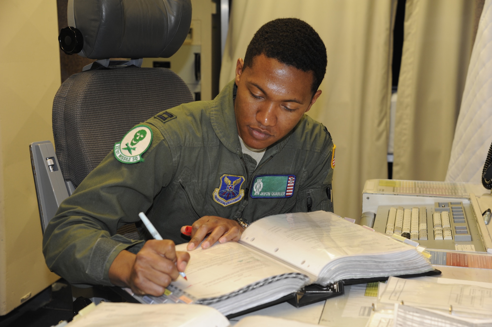 Capt. Javon Quarles, 321st Missile Squadron mission combat crew commander, reviews missile alert facility checklists during his second alert as an individual mobilization augmentee. Quarles served 4 years on active duty with the 321st MS and transitioned into the Air Force Reserve earlier this year.  (U. S. Air Force photo by Glenn S. Robertson)